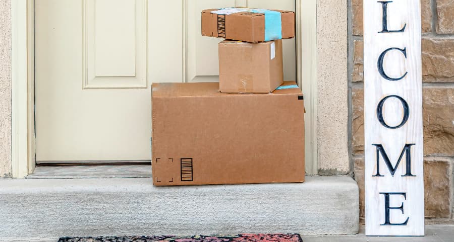 Packages on the doorstep of a home with a welcome sign in Lafayette